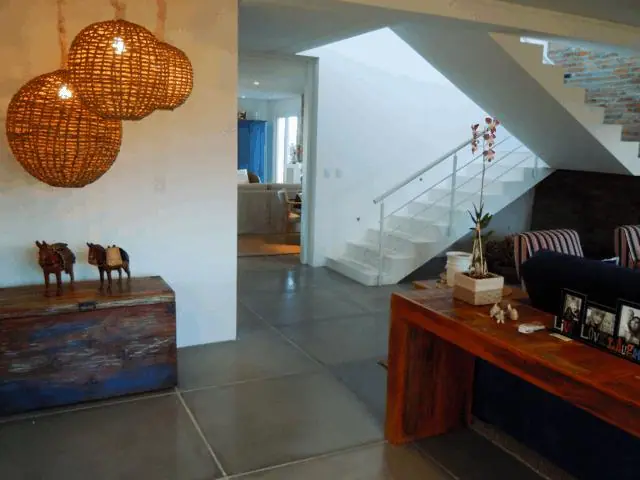 Hall de entrada com escada e revestimento de pedra clara